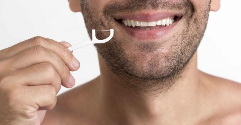 אדם מנקה שיניים באמצעות חוט דנטלי
